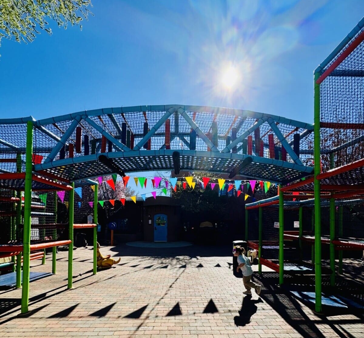 A little kid runs at the free playground infront of Twil in Taos